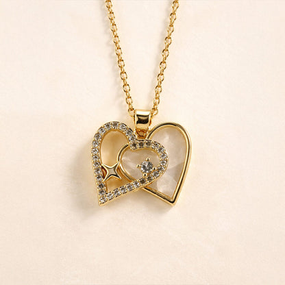 Gold heart-shaped necklace with embedded stones on a beige background