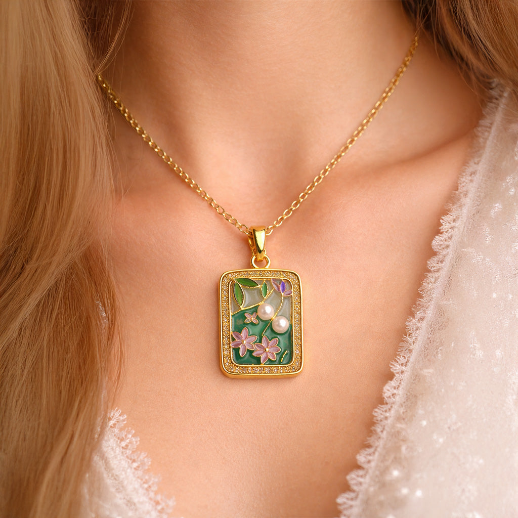 Gold necklace with a decorative pendant on a person wearing a white lace garment.