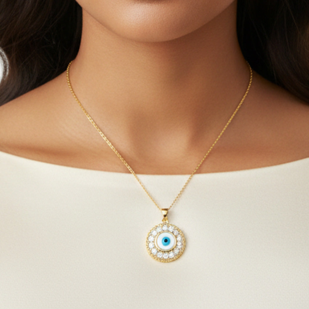 Gold necklace with a round pendant featuring a blue eye design on a plain background