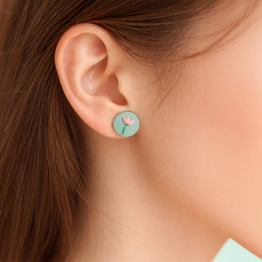 Pastel floral stud earrings on model front view